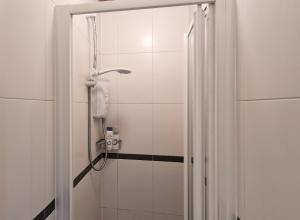 a bathroom with a shower with a phone in it at Walking distance to Grafton St in Dublin