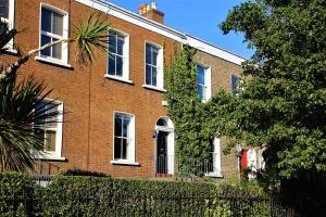 a red brick building with white windows and a fence at Walking distance to Grafton St in Dublin
