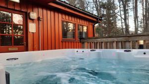 a hot tub in front of a cabin at Lagganlia Lodges and Camping Pods in Kincraig