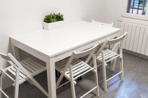 a white table and chairs with a potted plant at Casco Viejo 5 min, 3 HABITACIONES ,MODERNO,Garaje in Bilbao