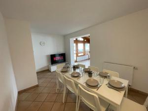 a dining room with a table and chairs and a tv at Worker Apartments near Ulm bis zu 11 Betten in Dornstadt