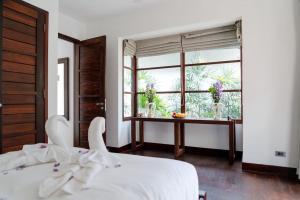 a bedroom with a white bed and a large window at Privatbeach residences villa 29 in Koh Samui  +32 photos