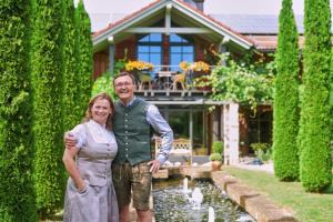 a man and a woman standing in front of a house at ÜbermAlztal Suite in Altenmarkt an der Alz +2 photos