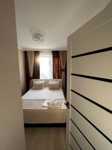 - une petite chambre avec un lit et une fenêtre dans l'établissement люкс квартира в центре города - все удобства - ждем Вас!, à Karaganda