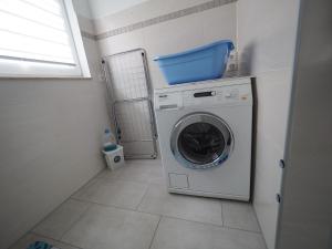 a laundry room with a washing machine and a window at Ferienwohnung Matersen in Matersen +2 photos