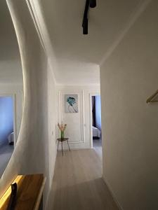 Cette chambre blanche dispose d'un escalier avec une table. dans l'établissement люкс квартира в центре города - все удобства - ждем Вас!, à Karaganda