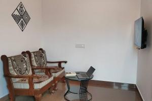 une chambre avec deux chaises et un ordinateur portable sur une table dans l'établissement Euphoria, a peaceful sanctuary, à Bangalore