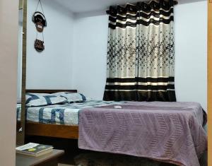 - une chambre avec un lit et un rideau dans l'établissement Euphoria, a peaceful sanctuary, à Bangalore