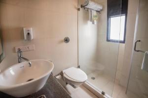 a bathroom with a sink and a toilet and a shower at Diamond Tree at Saket in New Delhi