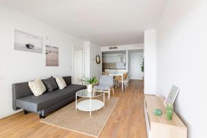 uma sala de estar com um sofá e uma mesa em Apartamentos en Canet al mar, junto playa y con piscina em Canet de Berenguer