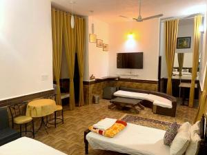 a room with two beds and a flat screen tv at Haveli Ashram & Resort in Ghānerao