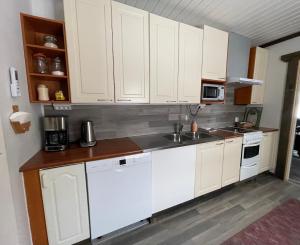 a kitchen with white cabinets and a sink at Beautiful rural experience with reindeer in Tervola