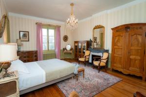 1 dormitorio con cama, escritorio y espejo en gîte ou chambres d'hôtes au château de Montclair, en Pommiers