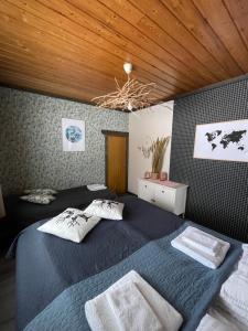 een slaapkamer met een blauw bed en een houten plafond bij Beautiful rural experience with reindeer in Tervola
