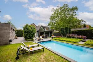 a backyard with a swimming pool and a house at Fabulous 4 Bedroom Villa (KS-10) in Eindhoven