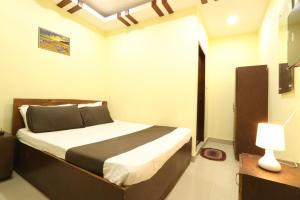 a bedroom with a bed and a lamp in it at ON GREEN RESIDENCY in Secunderabad