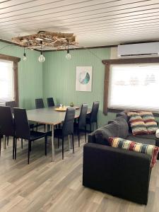 a dining room with a table and chairs and a couch at Beautiful rural experience with reindeer in Tervola