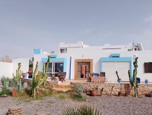Cette maison présente des murs blancs et des touches de bleu. dans l'établissement Riad Ocean Beach Douira, à Agadir