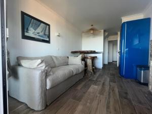 a living room with a couch and a blue door at Les Restanques du golfe de St Tropez in Grimaud