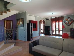 a living room with a couch and a staircase at Villa Borgo del Cilento in Albanella