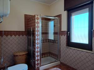 a bathroom with a shower with a toilet and a window at Villa Borgo del Cilento in Albanella +1 photo