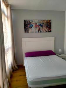- une chambre avec un lit blanc et une peinture murale dans l'établissement Lugo Comfort, à Lugo