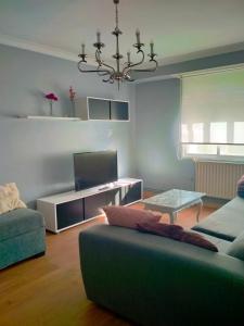 - un salon avec un canapé et une télévision dans l'établissement Lugo Comfort, à Lugo