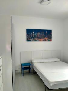 Cette chambre comprend deux lits et un tabouret bleu. dans l'établissement Lugo Comfort, à Lugo