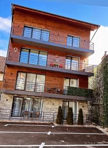 a brick building with windows and a parking lot at ANA Apartments Sinaia in Sinaia