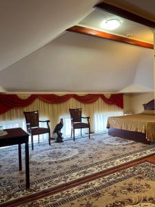 a man sitting in a room with two chairs and a bed at Vila Muntenia Hotel in Chişinău