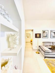 - un salon blanc avec un canapé et un lit dans l'établissement Sangiuliano Holiday Home, à Catane