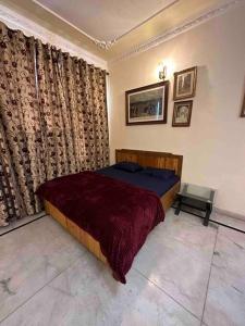 昌迪加爾的住宿－Anand Nilaya (2.5 km from Sukhna Lake, Chd)，一间卧室配有一张床和一把椅子