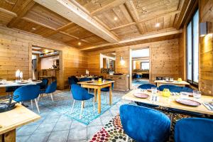 a restaurant with wooden walls and blue chairs and tables at L'Arveyron Open House in Chamonix