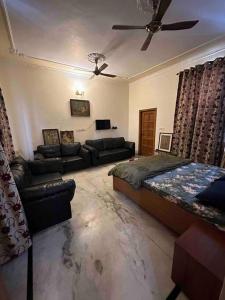 een slaapkamer met een bed, een bank en een plafond bij Anand Nilaya (2.5 km from Sukhna Lake, Chd) in Chandīgarh
