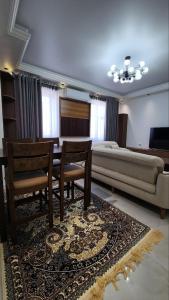 een woonkamer met een bed en 2 stoelen en een bank bij APARTMENT SILVER HOUSE in Samarkand