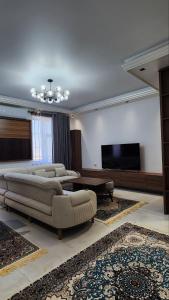 een woonkamer met 2 banken en een flatscreen-tv bij APARTMENT SILVER HOUSE in Samarkand