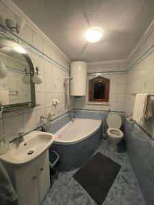 La salle de bains est pourvue d'une baignoire, d'un lavabo et de toilettes. dans l'établissement Magurska enklawa- domek letniskowy, à Nowy Żmigród