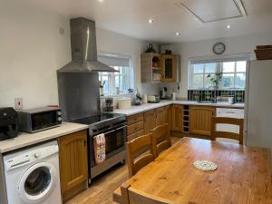 uma cozinha com uma mesa e um fogão forno superior em Dunnaglea Cottage, Ballintoy em Ballintoy