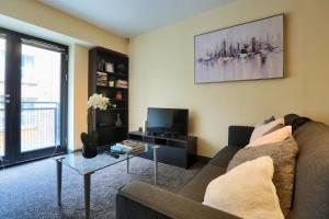 a living room with a couch and a tv at Lovely One Bed Apartment in Hip End of Temple Bar in Dublin