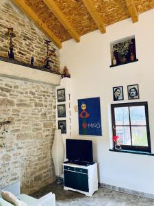 een woonkamer met een tv en een bakstenen muur bij Lucky Home - Apartment Art Grožnjan in Grožnjan