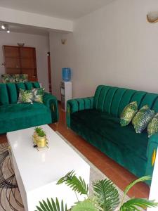 sala de estar con sofá verde y mesa en JABALI's Homestay, en Kisumu