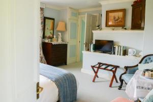 a bedroom with a bed and a tv in it at Colly Farm in Bridport