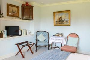 a room with a table and two chairs and a television at Colly Farm in Bridport