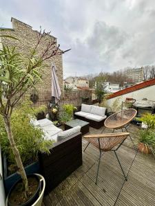 a patio with a table and chairs and a tree at 5P Chic Apt, Rooftop, Paris in Paris