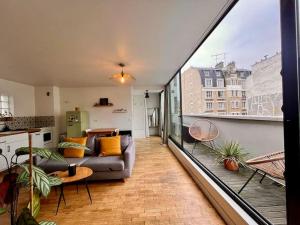 a living room with a couch on a balcony at 5P Chic Apt, Rooftop, Paris in Paris