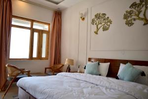 sypialnia z dużym łóżkiem i oknem w obiekcie Humming Bird By Aaryam w mieście Ukhimath