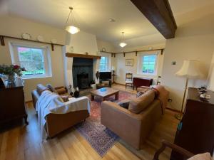 a living room with two couches and a fireplace at Dunnaglea Cottage, Ballintoy in Ballintoy