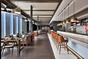 a restaurant with a long bar with wooden tables and chairs at Kathmandu Marriott Hotel in Kathmandu