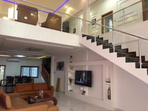 una sala de estar con una escalera en una casa en Maison d'architecte moderne, en Abomey-Calavi