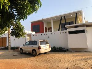 a car parked in front of a house at Maison d'architecte moderne in Abomey-Calavi